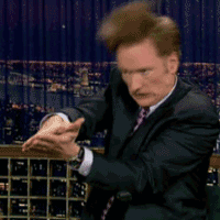 Animated GIF of Conan O'Brien clapping his hands together repeatedly while doing an aggressive chomping motion, reminiscent of an alligator